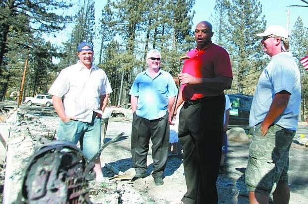 Charles Barkley, in red, looks at one of Tony Colombo&#039;s burnt golf clubs at Colombo&#039;s home on Mt. Olympia Circle in 2007 while Sayers Tanner, left, and Bob Spees, in blue, look on.
