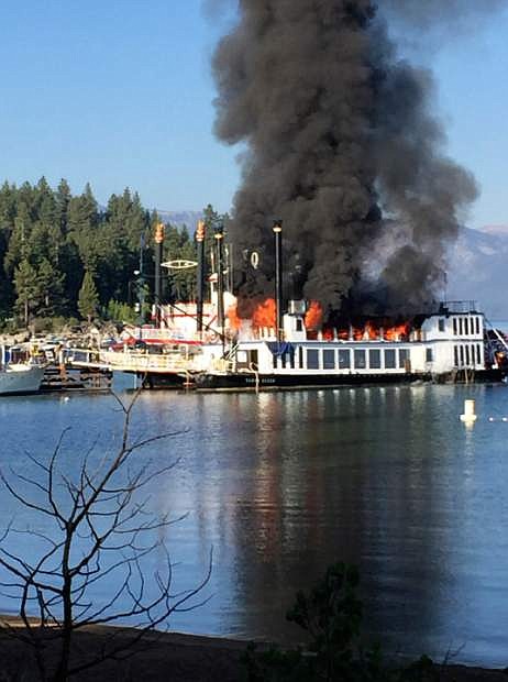 A fire rips through the second deck of a docked tourist cruise boat under repair at Lake Tahoe, in Reno, Nev., Tuesday, Aug. 16, 2016. The fire severely damaged the popular paddle wheeler and injuring two workers on board before crews extinguished the flames that sent a plume of black smoke high above the Sierra waters. (Zach Hastie via AP)