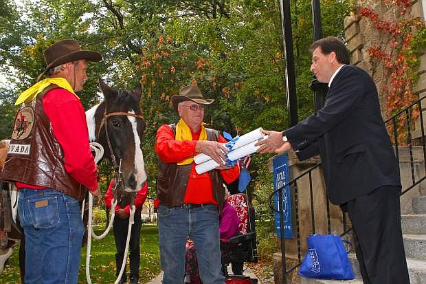 Lt. Gov. Brian Krolicki hands documents for delivery to Pony Express rider Ron Bell of Silver Springs on Oct. 17.
