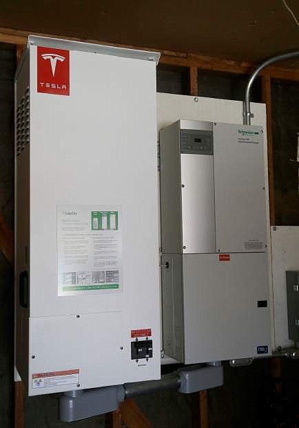 This April 20, 2015 photo shows a prototype Tesla battery system that powers the home of David Cunningham in Foster City, Calif. Cunnigham installed the battery late last year to pair with his solar panels as part of a pilot program run by the California Public Utilities Commission to test home battery performance. Tesla is expected to unveil a stationary battery for homeowners and businesses on Thursday, April 30, 2015. (AP Photo/Jeff Chiu)
