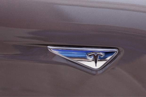 This Tuesday, April 7, 2015 photo, shows the Tesla logo on the automaker&#039;s Model S 70-D electric car, in Detroit. Tesla is going after mainstream luxury car buyers by boosting the range, power and price of its low-end Model S. The $75,000 all-wheel-drive 70-D can go a government-certified 240 miles per charge, has 514 horsepower and can go from zero to 60 in 5.2 seconds.  (AP Photo/Carlos Osorio)