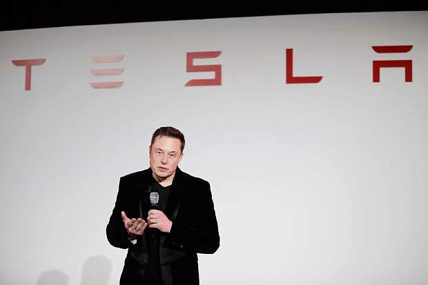 FILE - In a Sept. 29, 2015 file photo, Elon Musk, CEO of Tesla Motors Inc., talks about the Model X car at the company&#039;s headquarters, in Fremont, Calif. On Monday, Aug. 1, 2016, Tesla and SolarCity announced they have entered into an agreement under which Tesla will acquire SolarCity. Tesla will pay approximately $2.6 billion for solar panel maker SolarCity in an all-stock deal. (AP Photo/Marcio Jose Sanchez, File)