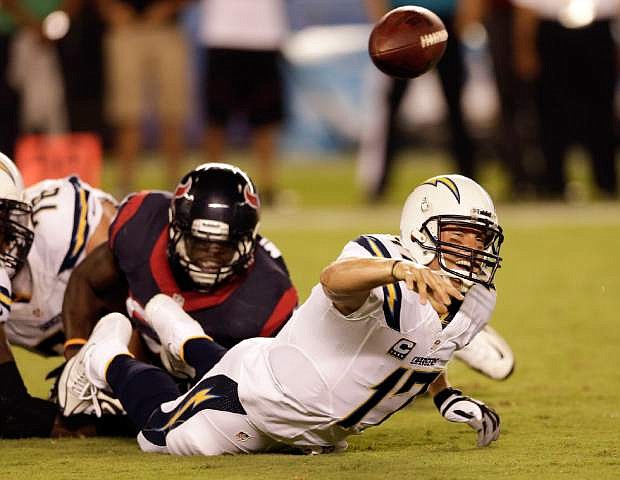 San Diego Chargers quarterback Philip Rivers, right, throws under pressure from Houston Texans outside linebacker Whitney Mercilus during the first half of an NFL football game Monday, Sept. 9, 2013, in San Diego. (AP Photo/Gregory Bull)