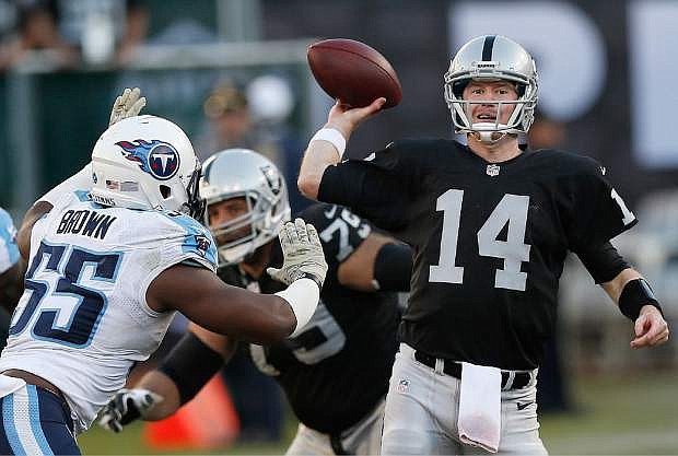 Oakland Raiders quarterback Matt McGloin (14) passes as Tennessee Titans outside linebacker Zach Brown (55) applies pressure during the fourth quarter of an NFL football game in Oakland, Calif., Sunday, Nov. 24, 2013. (AP Photo/Beck Diefenbach)