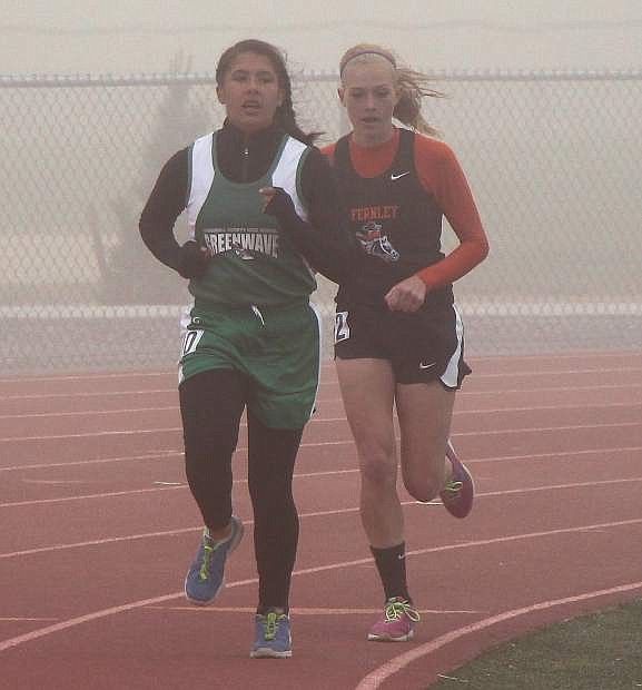 Fallon&#039;s Angelita Fermaint, left, and Fernley&#039;s Hailee Allen battle through a dust storm in the 3,200 race during Saturday&#039;s Fernley Invitational.