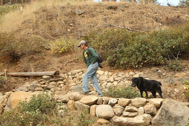 Trail builder Jeff Potter walks with his dog Tank up a switchback that he helped to construct on the multi-use trail between Ash and Kings canyons.