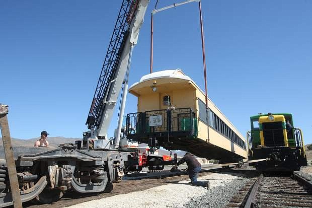 A crane moves one of the three-axle trucks for the new train car Jersey Lil onto the track at the Eastgate Station on Friday morning.
