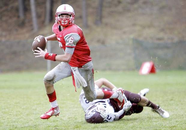 Truckee quarterback Tyler Davis, then a sophomore, escapes pressure during a home game against Elko last season.