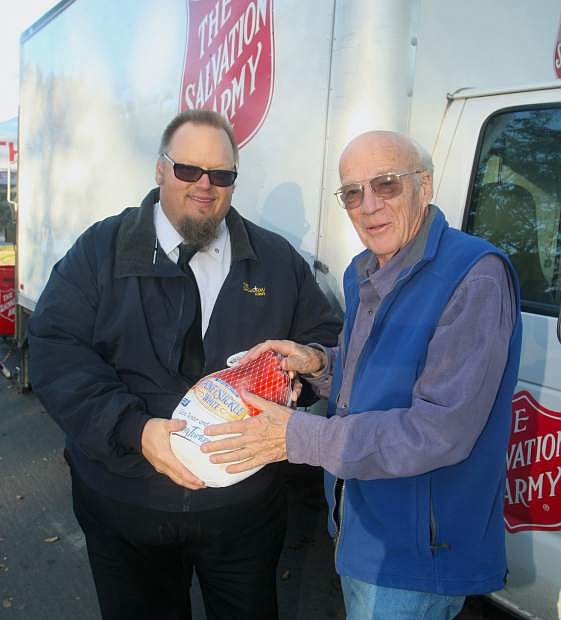 Lt. Mark Cyr with the Salvation Army accepts a turkey donation from Carson City resident Richard Long during the Salvation Army&#039;s annual turkey drive in front of Mike&#039;s Pharmacy on Tuesday.