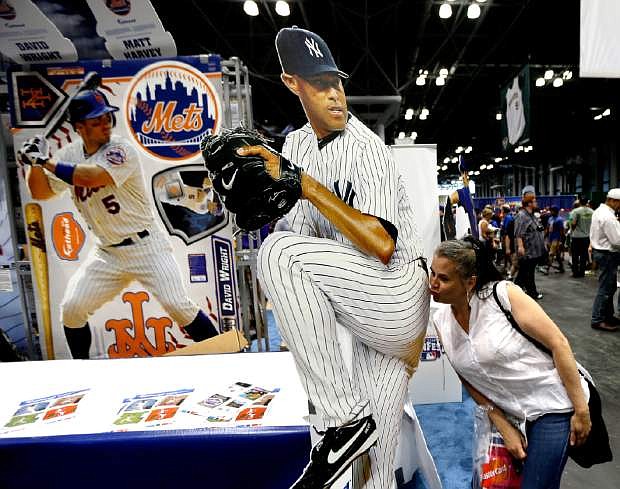 Evelis Cruz, of the Bronx borough of New York, kisses a cutout photo of New York Yankees pitcher Mariano Rivera while posing for a friend during the All-Star FanFest in New York&#039;s Javits Convention Center, Saturday, July 13, 2013. The five-day event is being held in conjunction with baseball&#039;s All-Star Game. (AP Photo/Julio Cortez)