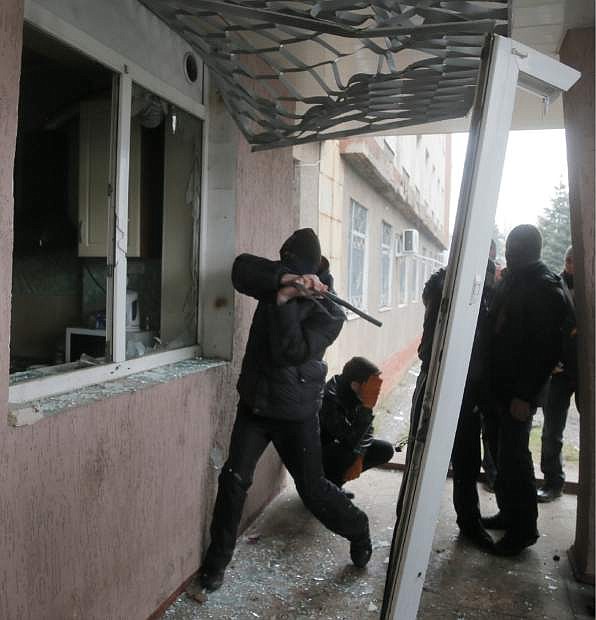 A Pro-Russian man attacks a police station in the eastern Ukrainian town of Horlivka Monday, April 14, 2014.  Several government buildings have fallen to mobs of Moscow loyalists in recent days as unrest spreads across the east of the country.  (AP Photo/Efrem Lukatsky)