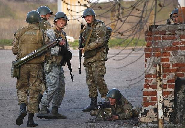 Ukrainian army troops set up a position at an airport in Kramatorsk, eastern Ukraine, Tuesday, April 15, 2014. In the first Ukrainian military action against a pro-Russian uprising in the east, government forces clashed Tuesday with about 30 armed gunmen at a small airport in Kramatorsk. (AP Photo/Sergei Grits)