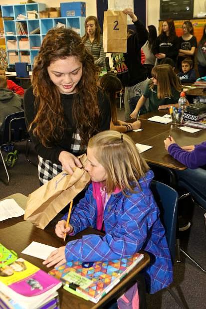 Koree Bostrom, 10, takes a sniff from Zoe Webb&#039;s bag during a presentation on personal hygiene Thursday. Bags 1 and 2 had pleasant smelling items in them while bag number 3 contained sweaty volleyball kneepads which highlighted the need for regular clothes washing to the 5th graders.