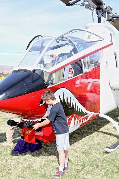 Dominic Perry, 12, of Dayton looks at the Gatling guns on the nose of a Huey Cobra Saturday at Mills Park.