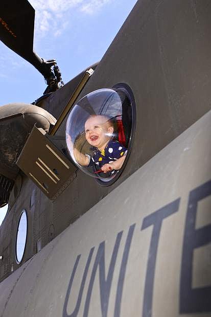 15-month-old Mary-Anne Byington peers out the bubble window of a U.S. Army Boeing CH-47 Chinook on display in Mills Park on Saturday.