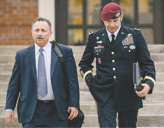 FILE - In this March 4, 2014, file photo, Brig. Gen. Jeffrey Sinclair, right, leaves the courthouse with his lawyers Richard Scheff, left, and Ellen C. Brotman, not pictured, following a day of motions at Fort Bragg, N.C. A military judge declined Monday, March 10, 2014, to dismiss sexual assault charges against Sinclair after reviewing what he said was evidence that political considerations influenced the military&#039;s handling of the case. (AP Photo/The Fayetteville Observer, James Robinson, File)