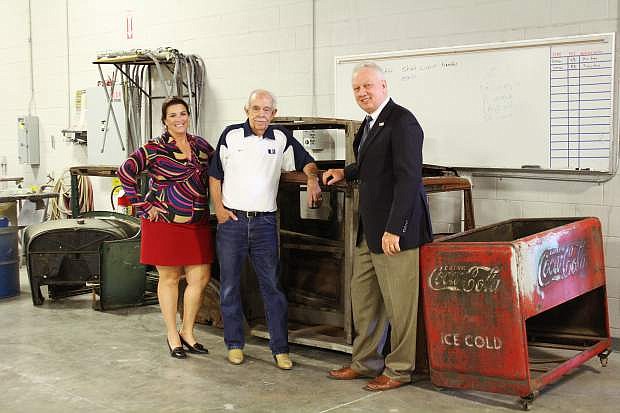 Western Nevada College Foundation board member Amy Clemens and Garth Richards, owner of Silver Oak Golf Course, and WNC President Chet Burton inspect some of the $15,000 worth of classic auto parts at the WNC auto body shop donated to the Foundation by Richards.