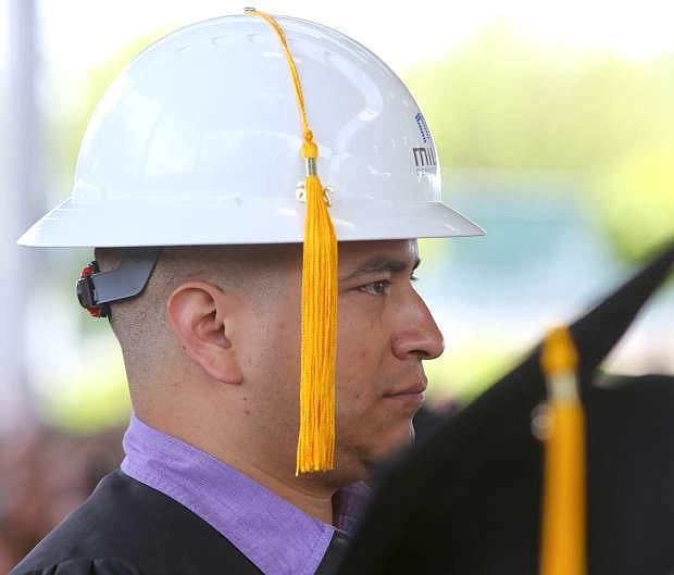 Carson City resident Victor Mejorado dons a hard hat before getting his a Bachelor of Technology in Construction Management degree at the 2016 Western Nevada College commencement on Monday.