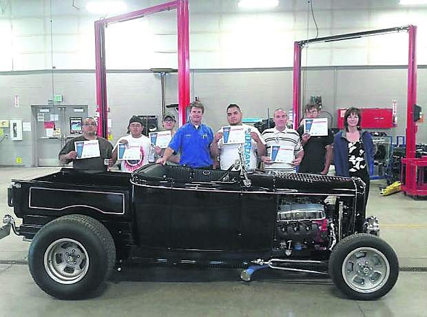 Johnnie Erwin, Samuel Simmons, Levi Greer, instructor Jason Spohr, Alan Bill, John Hull, Ethan Galloway and Trade Adjustment Assistance Community College &amp; Career Training grant manager Linda Devon pose with a 1932 Ford Roadster with their certifications.