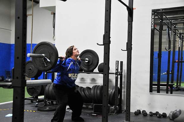 Makaylee Jaussi squats at Talents Athletic Center, an indoor sports facility that accommodates the Western Nevada College softball team when the weather prevents outdoor practice.