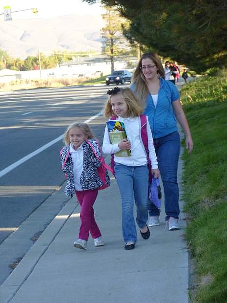 Lesley Schreckengost walks her daughters Kyla and Seren McGee to Fremont Elementary School on Wednesday as part of International Walk and Bike to School Day .