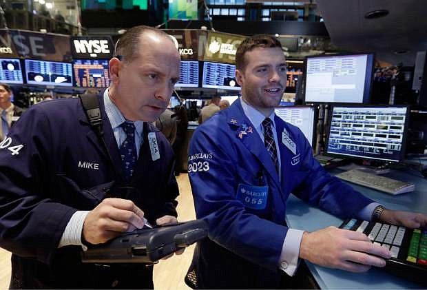 Traser Michael Urkonis, left, and specialist Frank Masiello work on the floor of the New York Stock Exchange Monday, Dec. 9, 2013. The stock market is opening little changed following last week&#039;s strong U.S. jobs report. (AP Photo/Richard Drew)