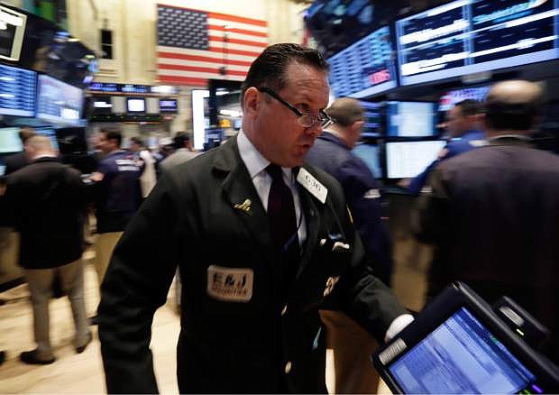 FILE - In this April 30, 2014 photo, trader Edward Curran rushes across the New York Stock Exchange floor. (AP Photo/Richard Drew, File)