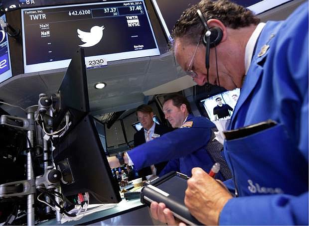 Trader Steven Kaplan, right, works at the post that handles Twitter, on the floor of the New York Stock Exchange, Wednesday, April 30, 2014.  Shares of Twitter dropped in morning trading Wednesday to their lowest point since the company went public in November. Investor concern remains over the short messaging service&#039;s ability to keep adding users and keep existing users engaged. (AP Photo)
