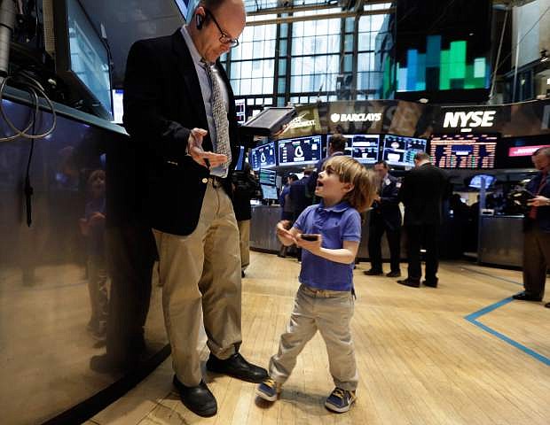 Tripp Mancuso, 4, works with his trader father Peter Mancuso on the floor of the New York Stock Exchange, during the NYSE Working Parents/Caregivers Employee Resource Group&#039;s annual Take Your Child to Work Day program, Thursday, April 24, 2014. Mixed earnings from a large number of U.S. companies left the stock market without direction early Thursday, despite positive results from a handful of names including Apple and Caterpillar. (AP Photo/Richard Drew)