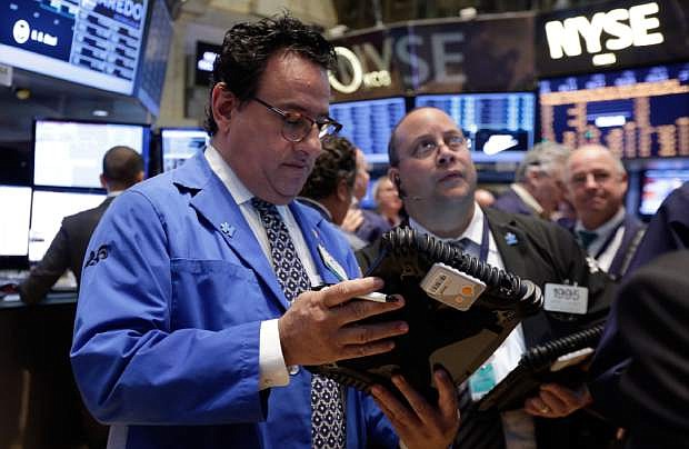 Peter Costa works with fellow traders on the floor of the New York Stock Exchange, Tuesday, April 22, 2014. Stock futures edged higher as more companies reported first quarter earnings. (AP Photo/Richard Drew)