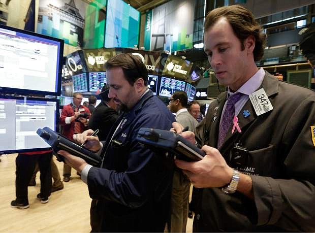 Thomas Cicciari, right, works with fellow traders on the floor of the New York Stock Exchange Monday, Nov. 18, 2013. The Dow Jones industrial average crossed 16,000 points for the first time early Monday and the Standard &amp; Poor&#039;s 500 index crossed 1,800 points. (AP Photo/Richard Drew)
