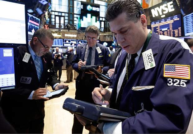 Trader William McInerney works on the floor of the New York Stock Exchange Wednesday, April 23, 2014.  A six-day rally on the stock market is petering out as some U.S. companies report earnings that disappoint investors. (AP Photo/Richard Drew)