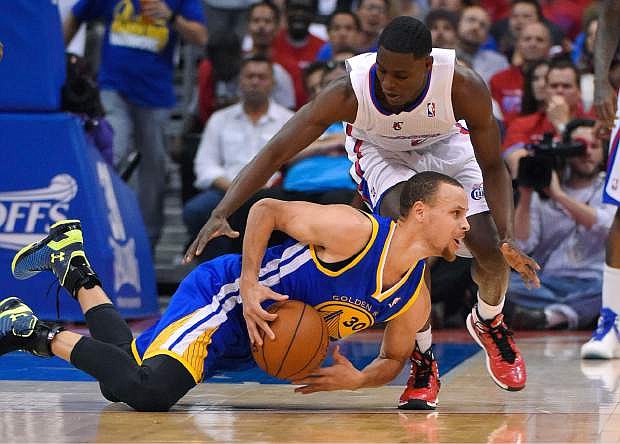Golden State Warriors guard Stephen Curry, below, tries to pass the ball from the floor under pressure from Los Angeles Clippers guard Darren Collison during the second half in Game 1 of an opening-round NBA basketball playoff series, Saturday, April 19, 2014, in Los Angeles. The Warriors won 109-105. (AP Photo/Mark J. Terrill)
