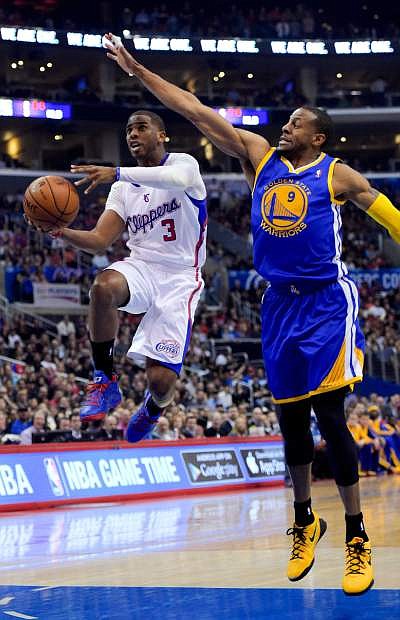 Los Angeles Clippers guard Chris Paul, left, drives past Golden State Warriors forward Andre Iguodala during the first half in Game 5 of an opening-round NBA basketball playoff series, Tuesday, April 29, 2014, in Los Angeles. (AP Photo)