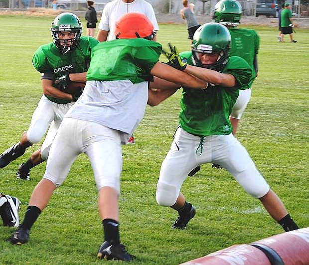 Fallon junior running back Nathan Heck, left, runs through the line during a drill. The Greenwave finished third last season in the Northern Division I-A.