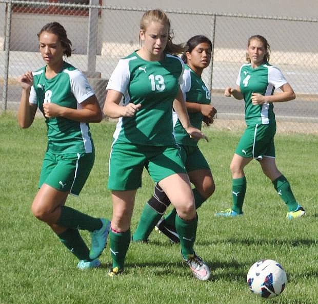 Fallon&#039;s Lady Wave soccer team clusters around a loose pass to take control during a passing drill on Monday.