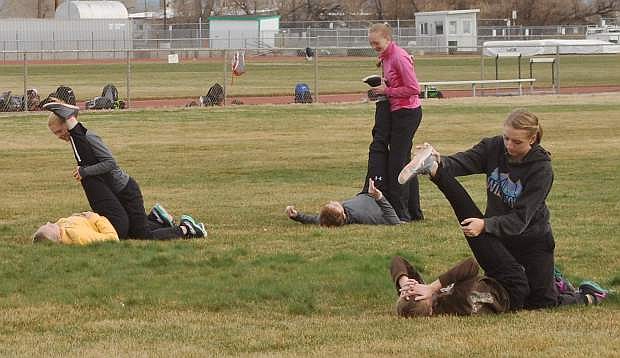 Members of the Greenwave girls track team stretch before practice on Wednesday.