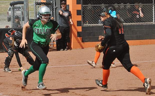 Fallon&#039;s Faith Cornmesser sprints to first while Fernley&#039;s infield crowd to field her bunt.