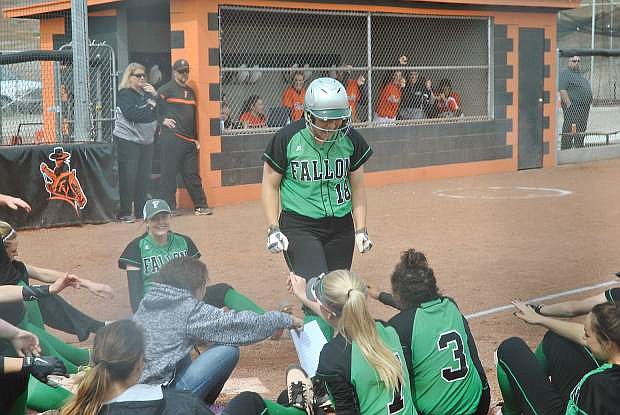 The Lady Wave&#039;s Paige Thorn stands while greeted comically by her team at home plate after hitting a two-run homer.