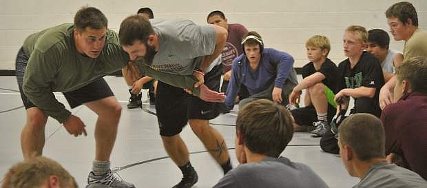 Fallon coach Trevor de Braga demonstrates a grapple for the Wave wrestling team in practice earlier in the season.