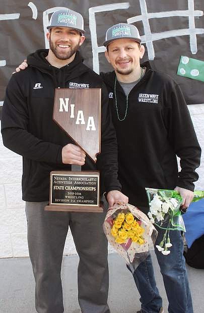 Coach Trevor de Braga, left, and assistant coach Daniel Shaw proudly hold the state wrestling trophy after returning to Fallon on Sunday.