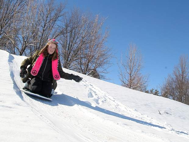 Emma Doty, 12, takes advantage of the recent snow storm to sled on a small hill near Carson Middle School on Monday afternoon.