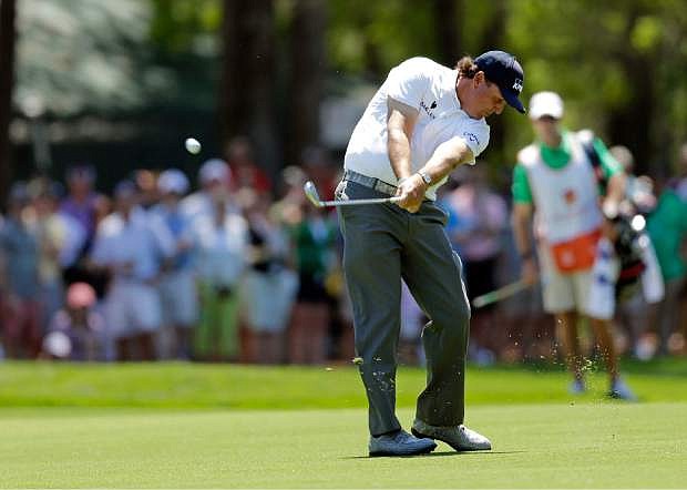 Phil Mickelson hits his approach shot on the ninth hole during the third round of the Wells Fargo Championship golf tournament in Charlotte, N.C., Saturday, May 3, 2014. (AP Photo/Chuck Burton)