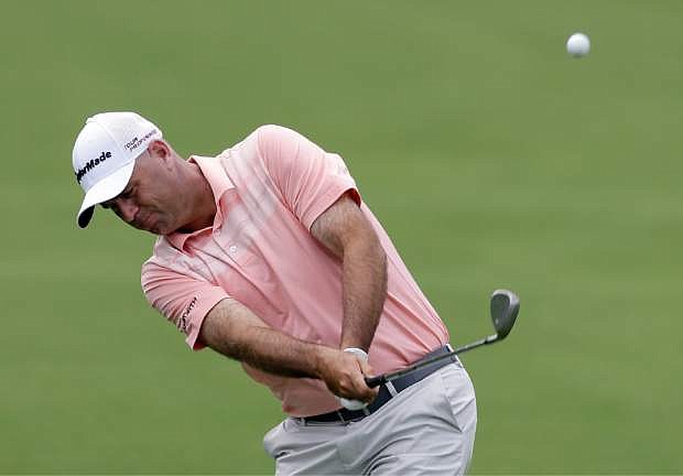 Stewart Cink hits his approach shot on the 18th hole during the first round of the Wells Fargo Championship golf tournament in Charlotte, N.C., Thursday, May 1, 2014. (AP Photo/Bob Leverone)