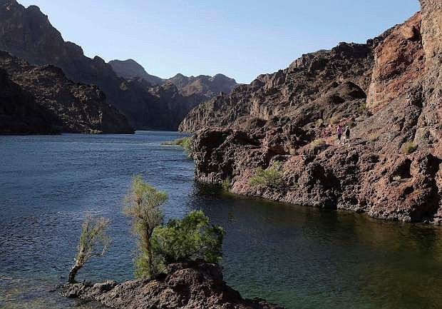 In this April 14 file photo, hikers make their way along the banks of the Colorado River in Black Canyon south of Hoover Dam, near Willow Beach, Ariz.