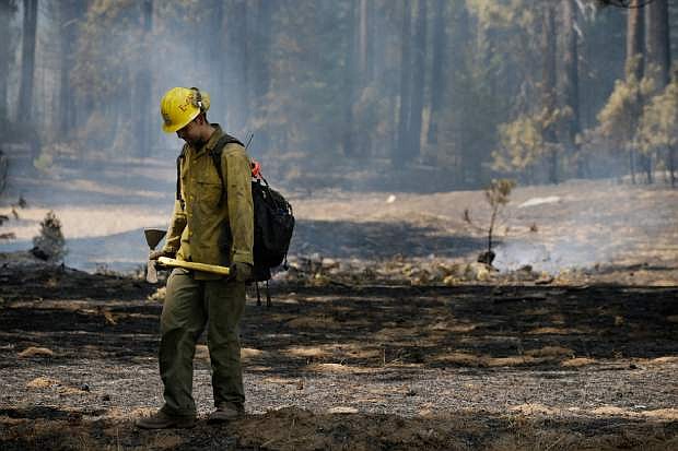 Firefighter Troy Drouin takes a short break before mopping up hot spots near Yosemite National Park, Calif., on Wednesday, Aug. 28, 2013. The giant wildfire burning at the edge of Yosemite National Park is 23 percent contained, U.S. fire officials said Wednesday. (AP Photo/Jae C. Hong)