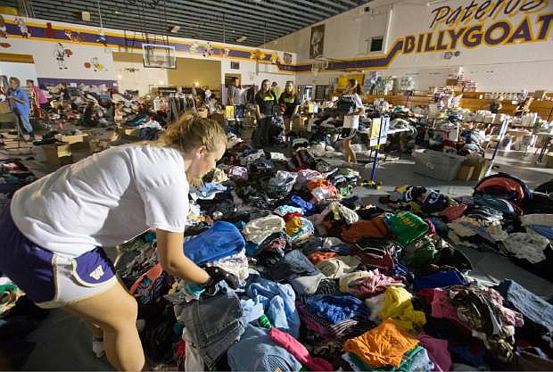 Shelby Nelson organizes clothes at the Pateros school, in Pateros, Wash., for area fire victims on Monday July 21, 20124. Nelson was with a group of volunteers from the Awaken Church in Wenatchee that was helping at the school. (AP PHOTO/WENATCHEE WORLD, MIKE BONNICKSEN)