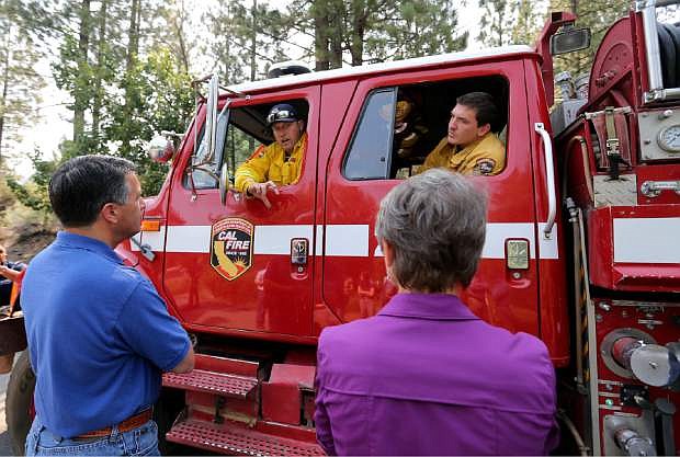 Nevada Gov. Brian Sandoval, left, and U.S. Secretary of the Interior Sally Jewell, right, talk with Cal Fire Capt. Chris Guidice, left, and Firefighter Brandon White in Markleeville, Ca. on Wednesday, June 24, 2015. The lightning-caused Washington fire has grown to nearly 17,000 acres since Friday. (AP Photo/Cathleen Allison)