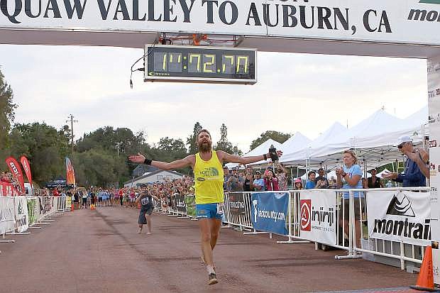 Rob Krar raises his arms in celebration as he nears the finish line of the Western States 100-Mile Endurance Run in Auburn on Saturday. Krar won the historic ultramarathon for the second straight year and was about two minutes off the course record.