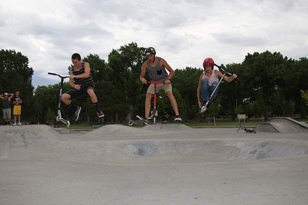 From left: Trevor Mills, 14 of Sonora, Ca., Peter Garrett and Jessy Silveira, both 15 of Carson, launch their scooters at the Mills Park skatepark on Thursday.